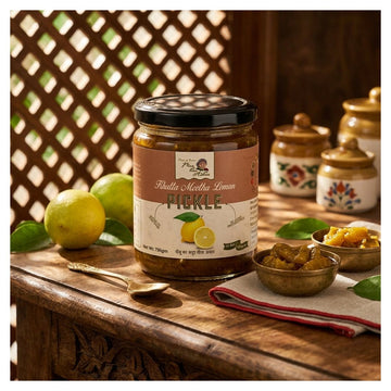 A jar of Lemon Pickle sits on a rustic wooden table, surrounded by fresh lemons, small bowls of the pickled contents, and matching decorative jars in the background.