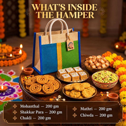 A festive gift hamper display with a blue, green, and beige paper bag standing on a decorated table, surrounded by Indian snacks including mohanthal, shakkar para, chakli, mathri, and chiwda. Text at the top reads 'WHAT'S INSIDE THE HAMPER' and a lower panel lists included items and weights.