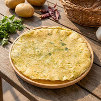 Potato papad on wooden plate with fresh potatoes, coriander and dried red chillies